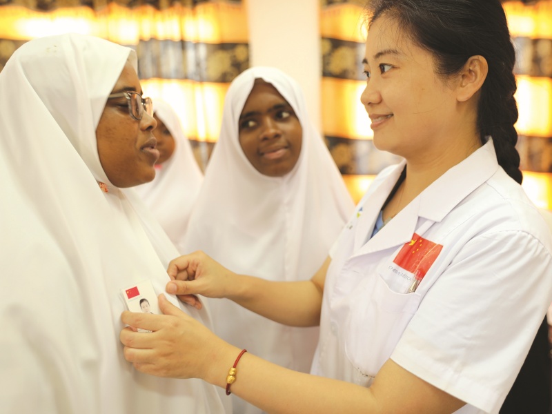 2019年6月14日，第28期援桑给巴尔医疗队在奔巴岛举行义诊，当地学生立志学医，并与医疗队副队长曹伟击掌为誓。曹伟向学生赠予自己的胸卡 (1).jpg